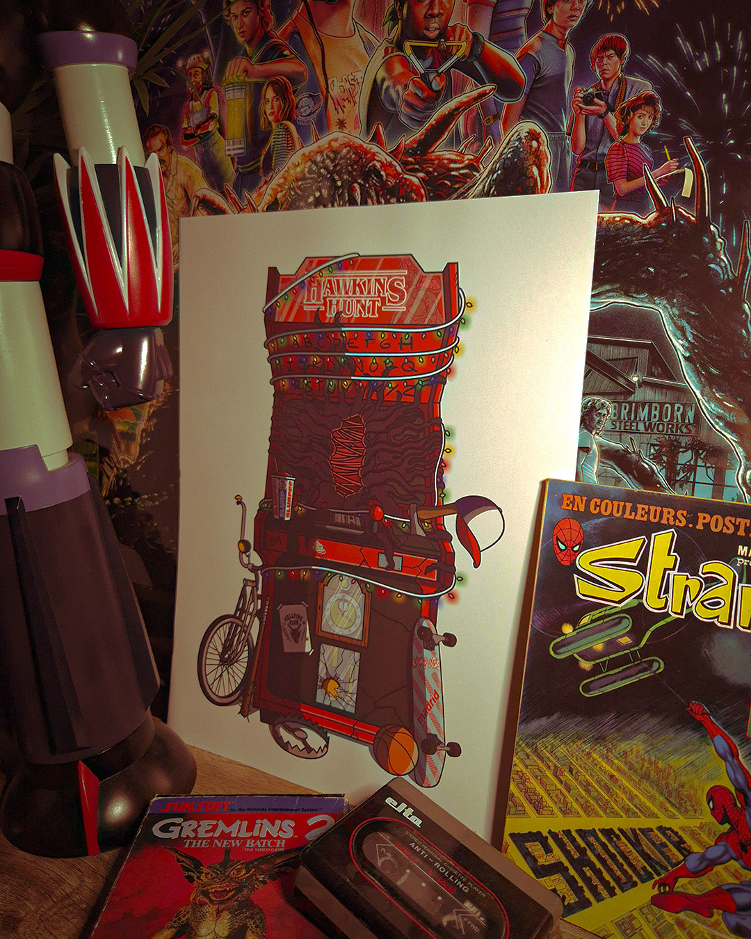Photo de mise en situation de l'affiche rétro vintage des années 80 représentant une borne d'arcade à l'image de la série Netflix "Stranger Things" avec pleins d'objets cultes. Création d'Enzo Beltoise.